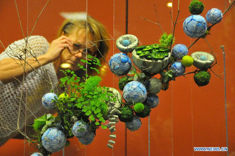 A visitor looks at a piece of plant art work during the Chicago Flower and Garden Show in Chicago, the United States, March 12, 2013. The Chicago Flower and Garden Show entered its fourth day on Tuesday. The show is held here from March 9 to March 17, featuring practical advice for Chicago land lawns, gardens and green spaces. (Xinhua/Jiang Xintong) 
