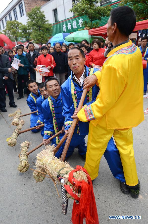 People from She ethnic group play grass dragon dance during a temple fair for the celebration of "Er Yue Er" in Donggu Shezu Township of Qingyuan District in Xiji City, east China's Jiangxi Province, March 13, 2013, on the occasion of the second day of the second lunar month, known in Chinese as Er Yue Er, "a time for the dragon to raise its head", as a Chinese saying goes. Local residents celebrated the festival with traditional performance to pray for a good harvest in the coming year. (Xinhua/Zhou Ke) 