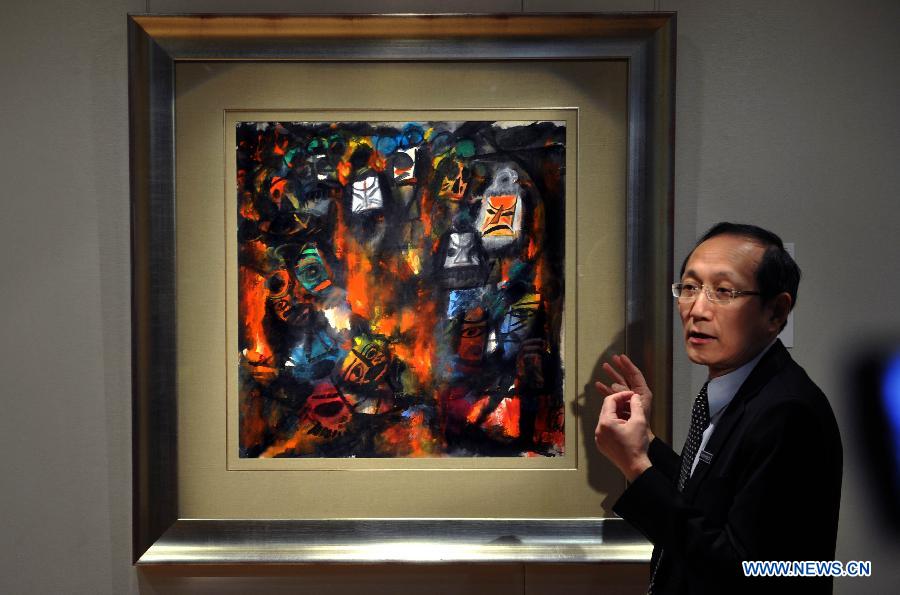 A working staff from the Sotheby's presents an artwork by Lin Fengmian valued at 3 million to 5 million Hong Kong dollars (about 386,700 to 644,500 U.S. dollars) in Hong Kong, south China, March 13, 2013. Sotheby's 2013 spring sales of fine Chinese paintings will be held on April 5 in Hong Kong. Over 300 pieces of artworks with a total value of more than 130 million Hong Kong dollars (about 16.6 million U.S. dollars) will be on display. (Xinhua/Chen Xiaowei)