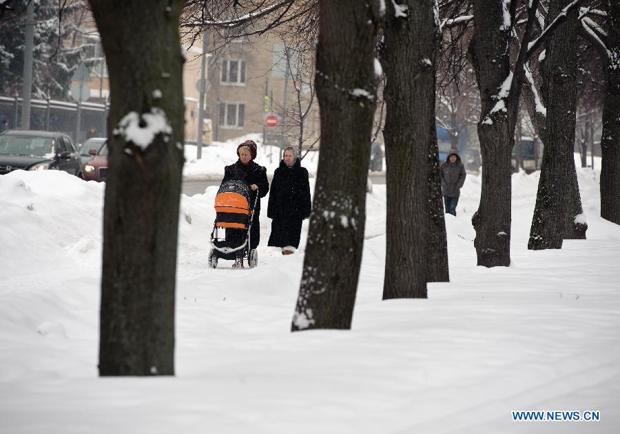 People walk during a snowfall in Moscow, Russia, March 14, 2013. A rare heavy snowfall hit Moscow on Wednesday and Thursday, causing traffic jams and disturbing scheduled flights. (Xinhua/Jiang Kehong) 