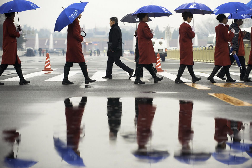 Staffs and members of CPPCC walk in Tian'anmen square in the rain. The closing meeting of the first session of the 12th National Committee of the Chinese People's Political Consultative Conference (CPPCC) was held on Tuesday. On the same day, Beijing embraced the first spring rain in 2013. (Xinhua News Agency/Liu Jinhai)