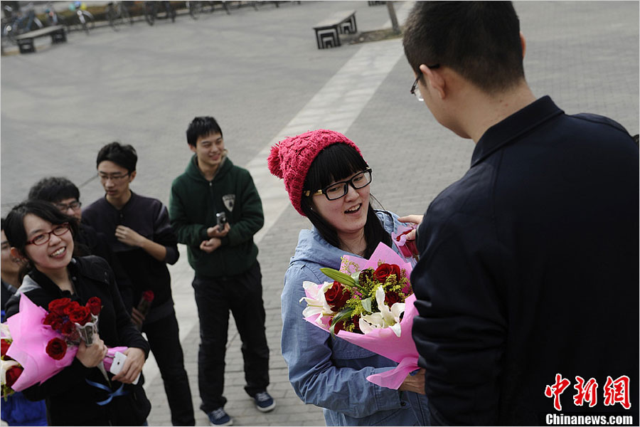 A Tsinghua University student sends flowers to his classmate to celebrate "Ladies' Day" on March 7, one day before "Women's Day" on March 8, 2013. Data issued by China's National Bureau of Statistics indicates that there will be 24 million more unmarried men than women by the end of 2020. (news.china.com.cn)