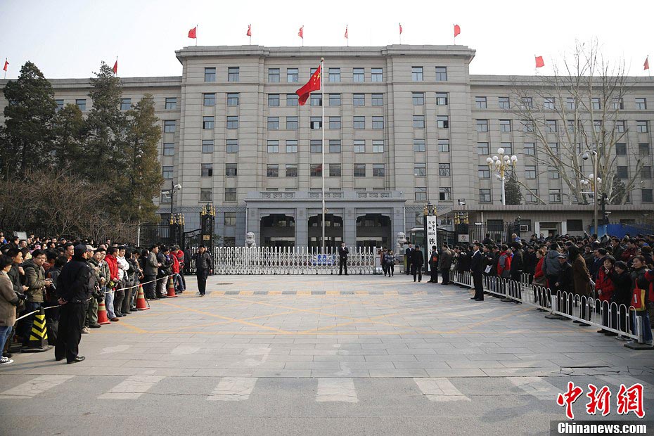 Nostalgic residents line up outside the headquarters of the Ministry of Railway to take photos with its sign yesterday afternoon. On the day, the first session of the 12th NPC endorsed the government restructuring plan, according to which the Ministry of Railway would be dissolved.（Photo/Chinanews.com）