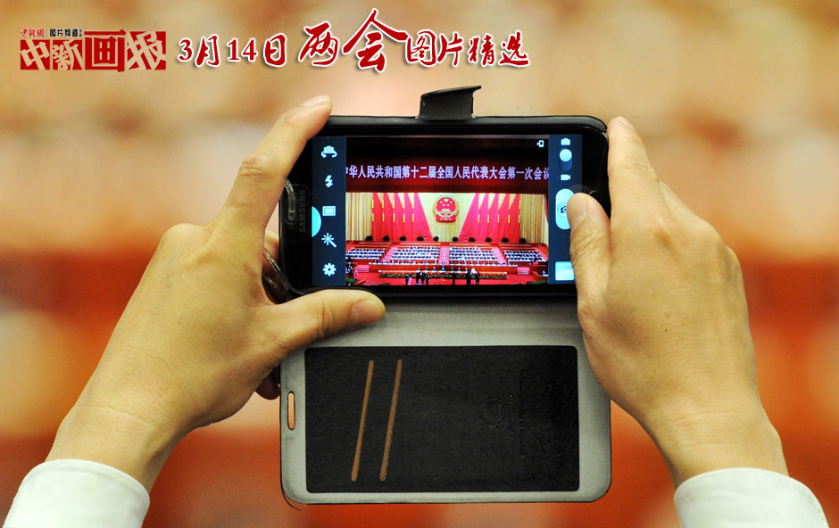 On March 14 the first session of the National People’s Congress holds 4th plenary meeting. Photo shows a reporter taking photos with his cellphone. (Chinanews.com/ Jia Guorong)