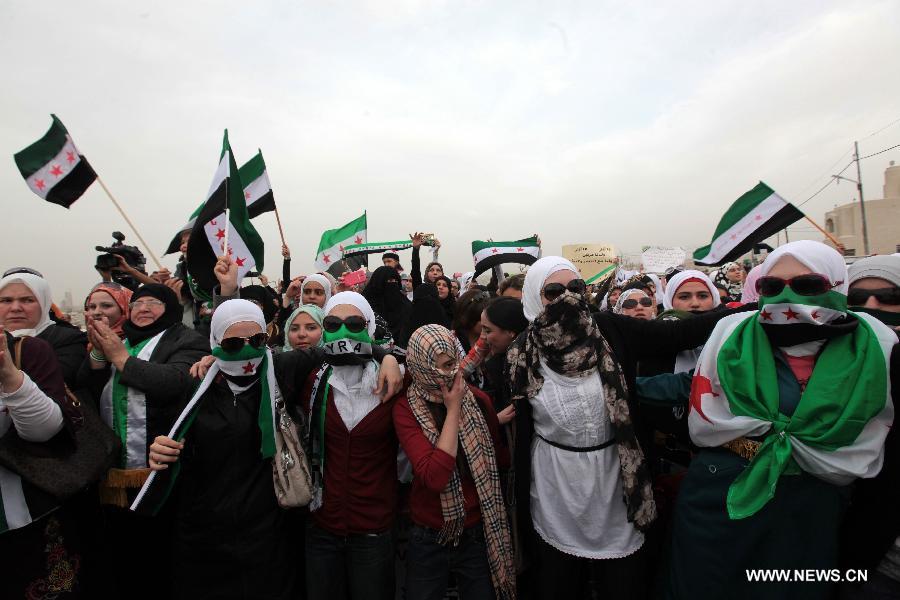 Syrians women living in Jordan hold Syrian revolutionary flags and shout slogans against President Bashar al-Assad during a rally in front of the Syrian embassy in Amman, Jordan, March 15, 2013. Hundreds gathered in front of the Syrian embassy to mark the second anniversary of the start of the conflict against the regime of Al-Assad. (Xinhua/Mohammad Abu Ghosh) 