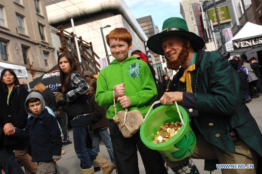 A boy poses with a man dressed as Leprechaun during Celtic Festival, part of St. Patrick's Day celebrations, in Vancouver, Canada, March 16, 2013. More than 200,000 spectators are expected to fill the streets of Vancouver's downtown on Sunday for the annual St. Patrick's Day parade. (Xinhua/Sergei Bachlakov)