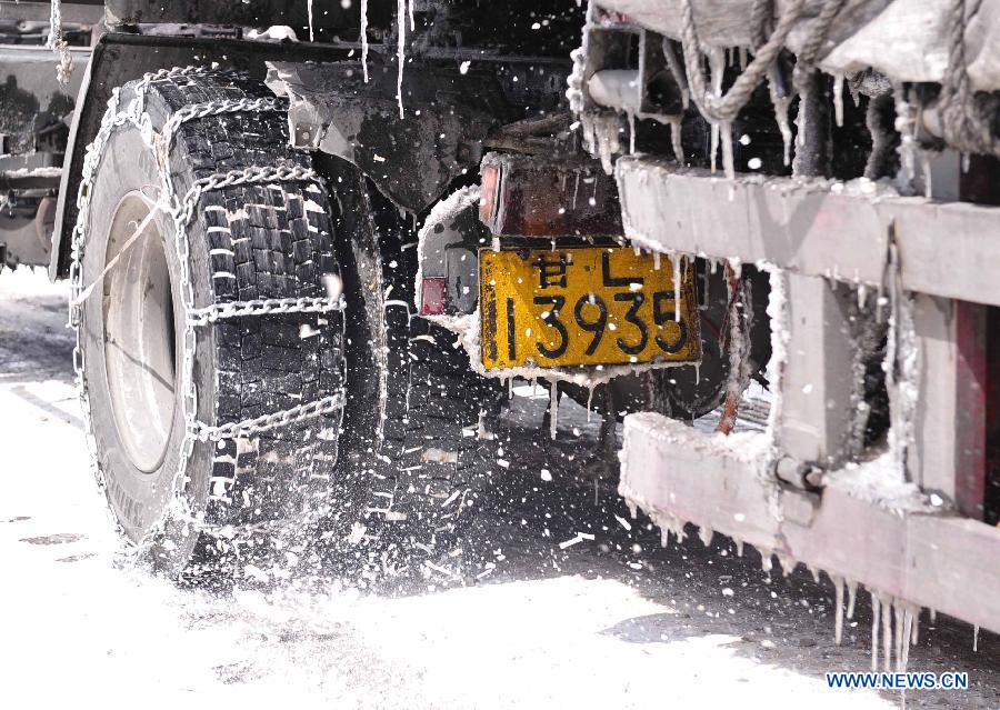A truck with tyres bound with skidproof chain runs on state highway 109 which is covered with snow near Nalong Village in Damxung County, southwest China's Tibet Autonomous Region, March 18, 2013. A snowstorm here made an icy road on the segement of state highway 109 near Nalong Village, causing many vehicles truck on the road. (Xinhua/Liu Kun)