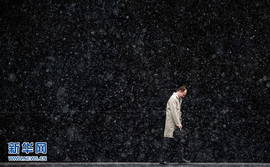 A pedestrian tries to shelter from snow in London, Monday, March 11, 2013. Temperatures in the capital plummeted to below freezing on last Monday. (Xinhua /AFP)
