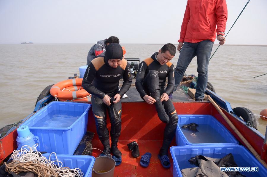 Frogmen get ready to dive in the Laoyemiao water area of the Poyang Lake, east China's Jiangxi Province, March 18, 2013. Archaeologists discovered a sunk ship in the Laoyemiao area of the Poyang Lake, China's largest freshwater lake on Monday. The Laoyemiao area in the lake is often referred to as "China's Bermuda Triangle" because of the large number of boats that sank mysteriously in the area over the years. (Xinhua/Zhou Mi)