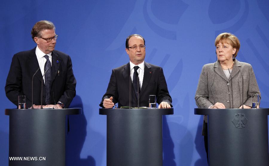 French President Francois Hollande (C) speaks as German Chancellor Angela Merkel (R) and CEO of Ericsson Leif Johansson look on during a joint press conference prior to the European Round Table of Industrialists, at the Chancellery in Berlin, Germany, March 18, 2013. The leaders of Germany, France and the European Union Commission pledged to boost growth and competitiveness of the European economy at a meeting on Monday in the German capital. (Xinhua/Pan Xu)