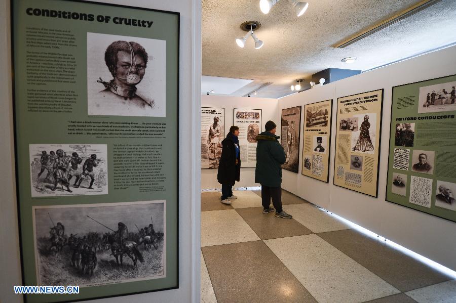 People look at illustrations on display during an exhibition commemorating the abolishment of slavery, at the United Nations (UN) headquarters in New York, on March 18, 2013. Beginning on Monday, the UN will be hosting a week of activities to highlight the significance of March 25, the International Day of Remembrance of the Victims and the Transatlantic Slave Trade. (Xinhua/Niu Xiaolei)