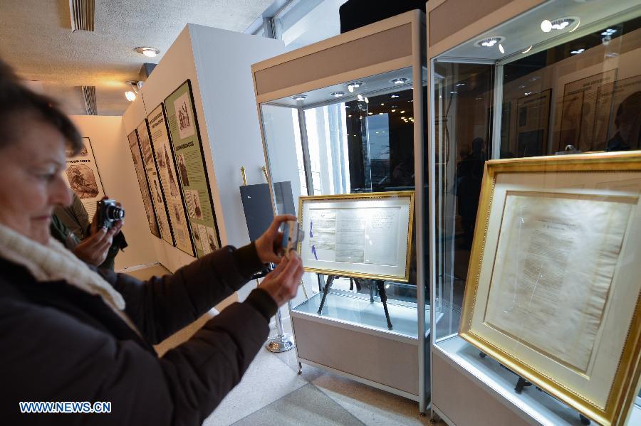 People take pictures of original copies of the Emancipation Proclamation signed by Abraham Lincoln and the Thirteenth Amendment to the United States Constitution, during an exhibition commemorating the abolishment of slavery, at the United Nations (UN) headquarters in New York, on March 18, 2013. Beginning on Monday, the UN will be hosting a week of activities to highlight the significance of March 25, the International Day of Remembrance of the Victims and the Transatlantic Slave Trade. (Xinhua/Niu Xiaolei)