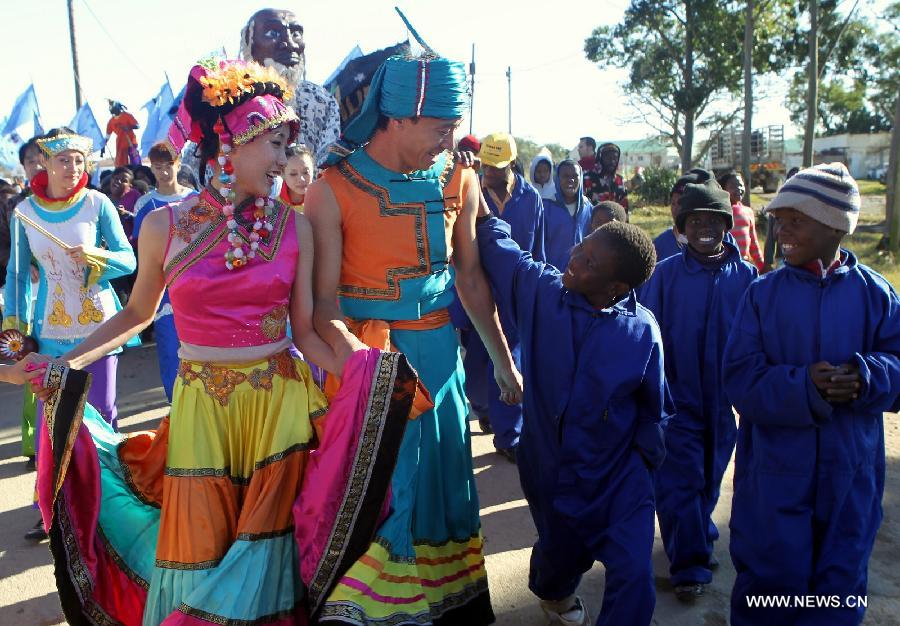 Members of China's Tianjin Performing Art Troupe take part in a parade with local children in Grahamstown, South Africa, July 9, 2011. Cultural and people-to-people exchanges have been reinforced between China and African countries over past decades, thus deepening mutual understanding and traditional friendship between the two peoples. Chinese President Xi Jinping will visit Tanzania, South Africa and the Republic of Congo later this month and attend the fifth BRICS summit on March 26-27 in Durban, South Africa. (Xinhua/Liang Quan) 