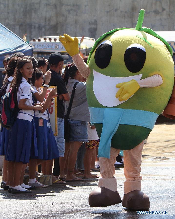 A performer in a mango-like costume waves to people on a street during the Mango Festival in Zambales Province, the Philippines, March 20, 2013. The Mango Festival is held in Zambales annually to promote mango as the local signiture with colorful floats and street dances. (Xinhua/Rouelle Umali)