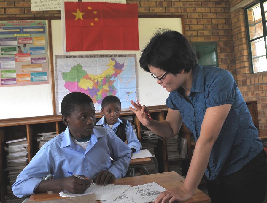 Shaodan, a Chinese teacher of Confucius Institute, teaches Chinese at a secondary school, 40 km east of Pretoria, South Africa, Feb. 25, 2013. In recent years, Africa has witnessed a growing passion for the Chinese language and increasing requests to set up Chinese teaching institutions. To cater to this growing need, China opened the Confucius Institute at the University of Nairobi in 2005, the first of its kind in Africa. The latest figure shows that there are 31 Confucius Institutes and 5 Confucius Classrooms in Africa as of September 2012. (Xinhua/Li Qihua)