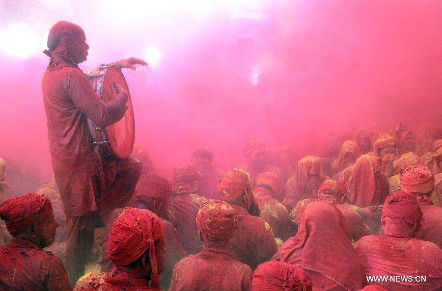 People from the village of Nandgaon are covered in colored powder during prayers at the Ladali or Radha temple before the procession for the Latthmaar Holi festival at village Barsana near Mathura city of Indian state Uttar Pradesh, March 21, 2013. (Xinhua/Partha Sarkar)