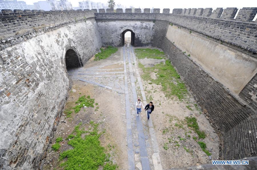 Tourists visit the Urn City which is fenced by old city walls in Xiangyang, central China's Hubei Province, March 21, 2013. (Xinhua/Li Xiaoguo)