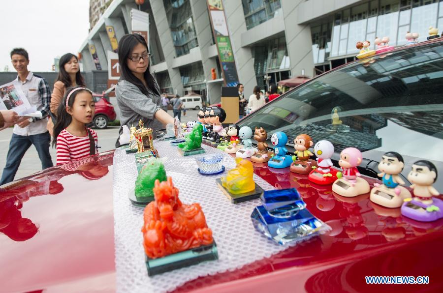 Shoppers choose ornaments at a weekend trunk market held by a local auto club at Beibin Road in Chongqing, southwest China's municipality, March 23, 2013. (Xinhua/Chen Cheng) 