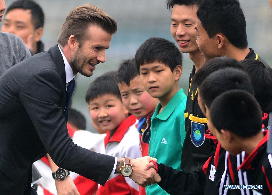 Football superstar, ambassador for the Chinese Super League (CSL) and the Youth Football Program, David Beckham (L) shakes hands with young football players at Hankou recreation and sports center in Wuhan, capital of central China's Hubei Province, March 23, 2013. (Xinhua/Cheng Min) 