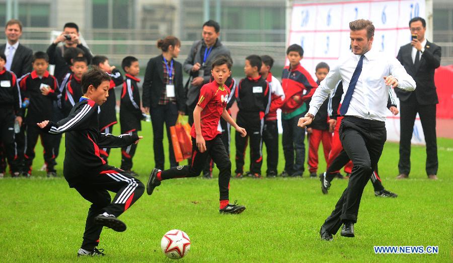 Football superstar, ambassador for the Chinese Super League (CSL) and the Youth Football Program, David Beckham (R) plays football with young players at Hankou recreation and sports center in Wuhan, capital of central China's Hubei Province, March 23, 2013. (Xinhua/Cheng Min) 