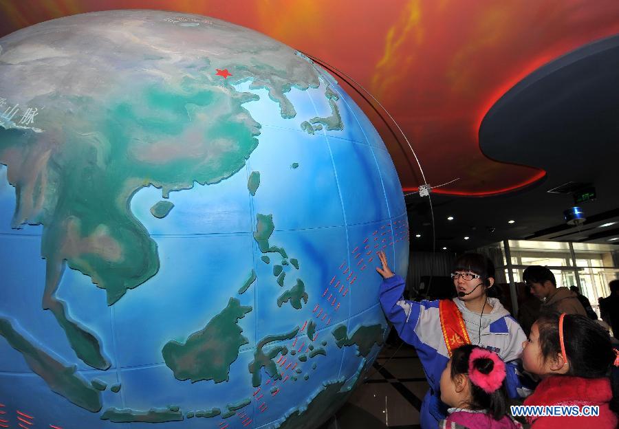 High school student Zhu Jie from the High Shcool Affiliated to Beijing Institute of Technology volunteers to introduce a space observation system to visitors on the open day at China Meteorological Administration in Beijing, capital of China, March 23, 2013, the World Meteorological Day. (Xinhua/Chen Yehua) 