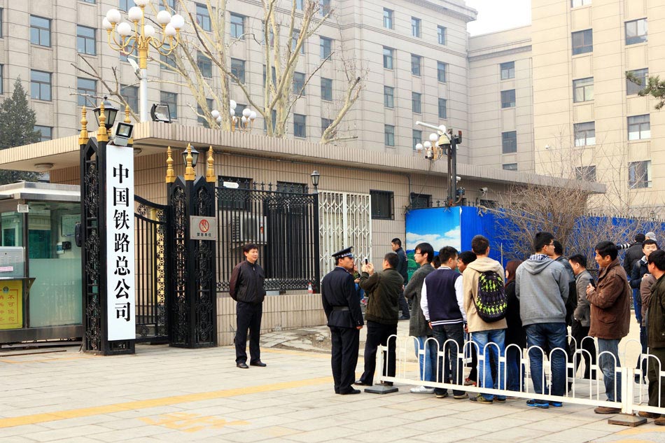 People line up to take souvenir photo with the sign of China Railway Corporation, which replaced the Ministry of Railways to be China’s national railways operator, Beijing, March 17, 2013. (Xinhua/Xu Zijian)