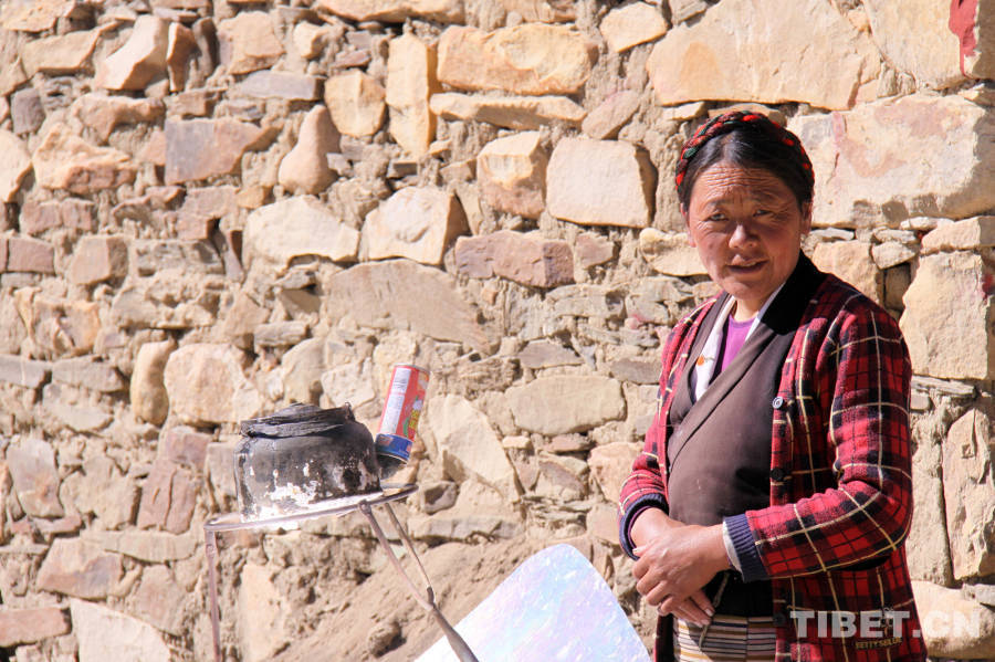 A Tibetan woman boils water by solar energy. (Photo by Xi Qin)