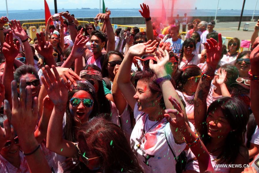 People with colored powder on their faces dance during the Holi Festival in Pasay City, the Philippines, March 24, 2013. The Holi Festival is one of the major festivals in India, celebrating the turn of the seasons from winter to spring. Also known as the Festival of Colors, it is a fun-filled celebration during which hundreds of people gather to enjoy a day of dancing, eating and throwing colored powder at one another. (Xinhua/Rouelle Umali)