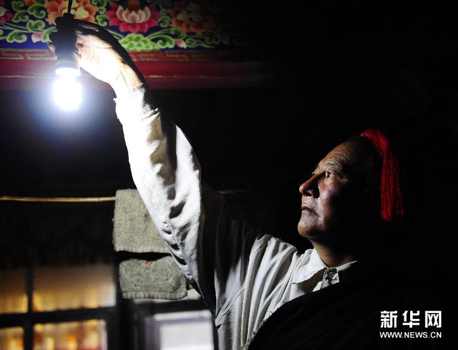 Uncle Tashi from Langchen village in Biru county of Tibet Autonomous Region turns on the light. [Photo/Xinhua]