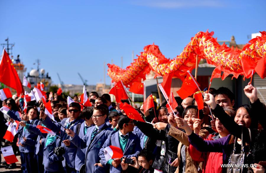 Local Chinese and Maltese people wave flags during a welcoming ceremony at the Grand Harbour in Valletta, Malta on March 26, 2013. The 13th Escort Taskforce of the Chinese Navy arrived in Valletta, Malta on Tuesday, beginning a five-day visit to the country. (Xinhua/Xu Nizhi) 