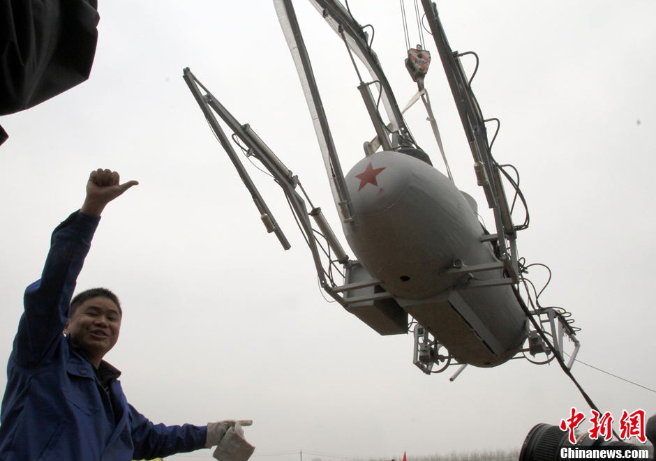 Zhang Wuyi tests his invention, an unmanned underwater fishing device, in Wuhan on March 26, 2013. The “civil submarine” is equipped with a remote control and a camera for picking up image underwater. (Photo by Zhang Chang/ Chinanews.com)