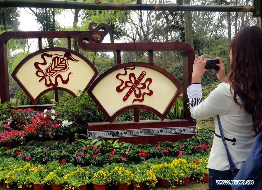 A visitor takes photos of azalea blossoms at the Humble Administrator's Garden in Suzhou City, east China's Jiangsu Province, March 28, 2013. (Xinhua/Wang Jiankang)