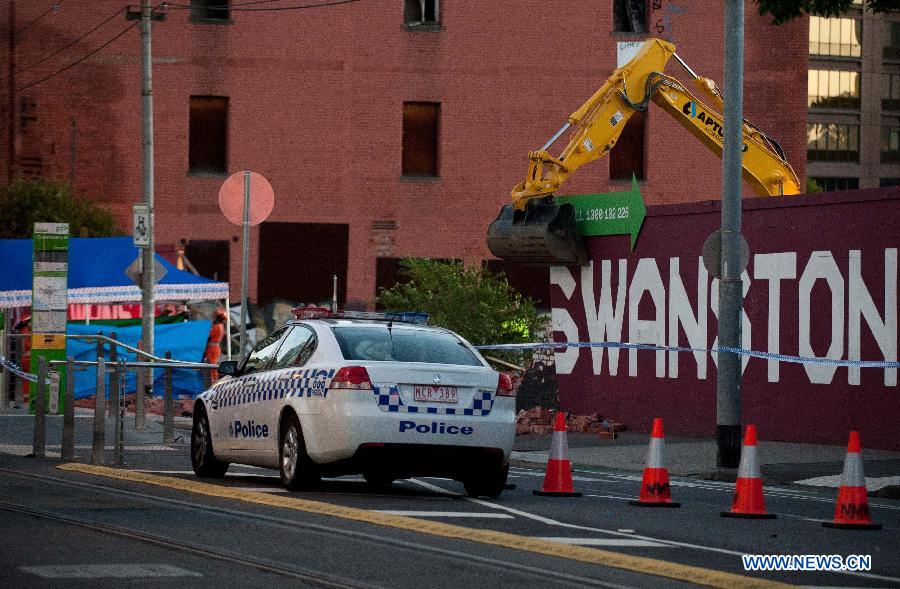 A police car parks near the collapsed wall in Melbourne, Australia, March 28, 2013. A wall at Swanston street collapsed, causing 2 people dead and another person injured.(Xinhua/Bai Xue) 