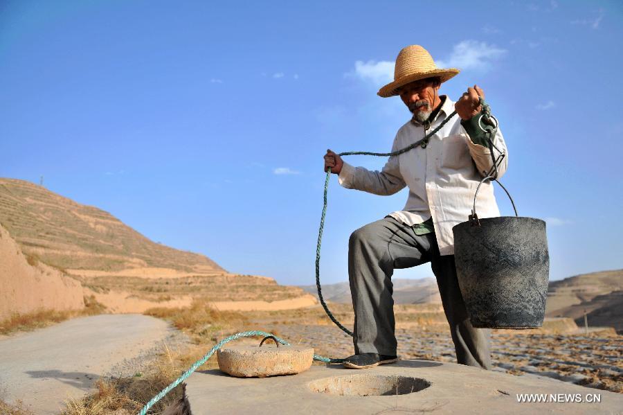 Villager He Faquan gets water from a water well which is almost dried up in Qingshui Village of Lujiagou Township in Dingxi City, northwest China's Gansu Province, March 28, 2013. A drought lingering Gansu Province has caused 650,000 people lack of drinking water. (Xinhua/Chen Bin)