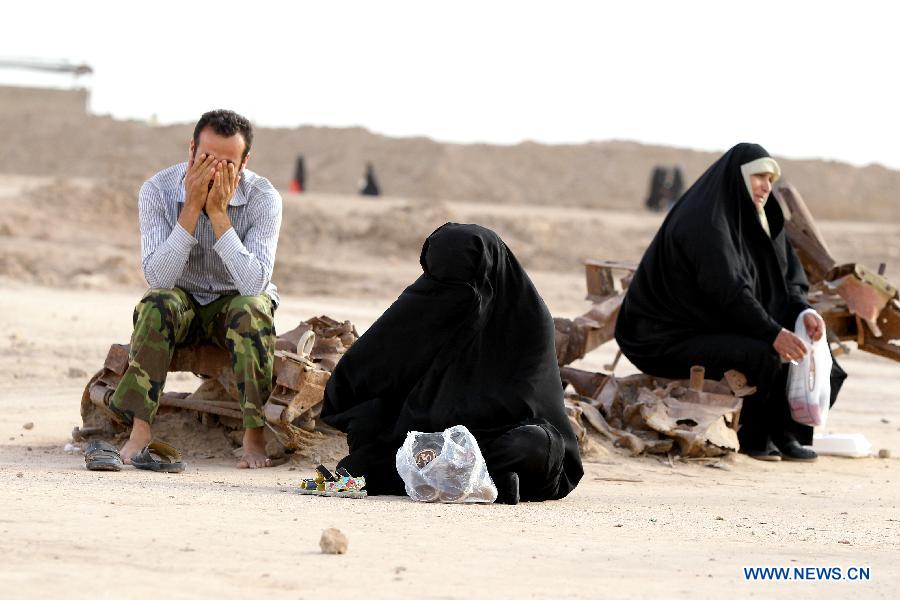 Iranians cry as they visit Talaeiyeh, a battlefield of the 1980-1988 Iran-Iraq war, in Iran's southwestern province of Khuzestan, during the Iranian New Year holidays on March 29, 2013. (Xinhua/Ahmad Halabisaz) 