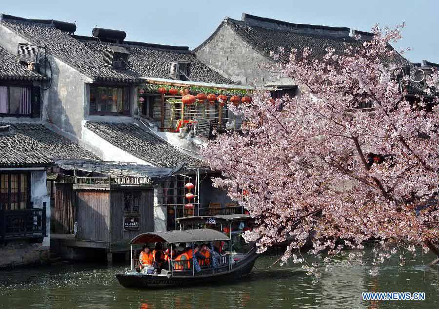 Visitors take boats while touring in the Xitang Township of Jiaxing City in east China's Zhejiang Province, March 30, 2013. Xitang, a township which enjoys thousand years' history, embraced large numbers of visitors recently. (Xinhua/Wang Song)