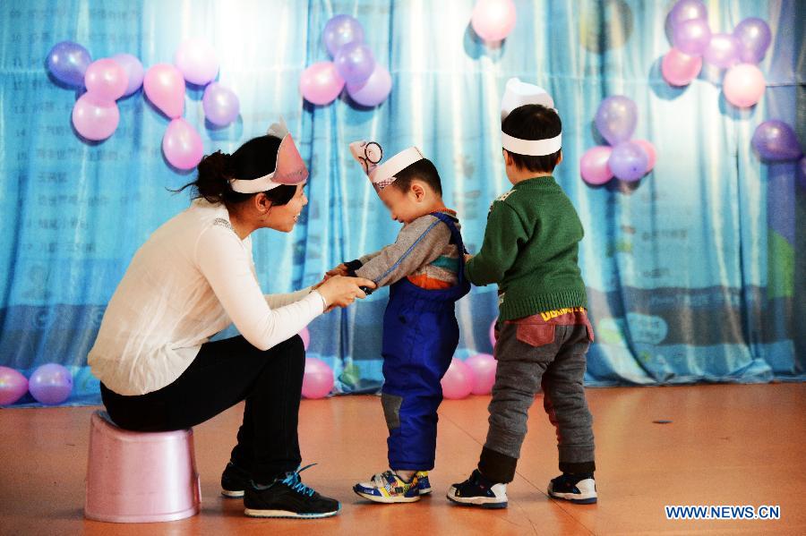 A woman and two autistic children perform at a rehabilitation center for autistic children in Harbin, capital of northeast China's Heilongjiang Province, April 2, 2013, on the occasion of the World Autism Awareness Day. (Xinhua/Wang Kai)