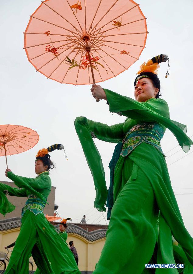 Women dressed in costumes of Northern Song Dynasty (960-1127) perform in a spring parade for the upcoming Tomb-sweeping Day in Kaifeng, central China's Henan Province, April 3, 2013. Thousands of performers and citizens participated in the parade. (Xinhua/Wang Song)