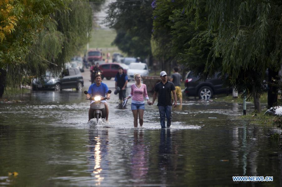 Citizens walk in flood in La Plata, 63 km south of Buenos Aires, Argentina, on April 3, 2013. At least 46 people have died due to heavy storms in La Plata, and another 3,000 have been evacuated, according to local media. (Xinhua/Martin Zabala) 