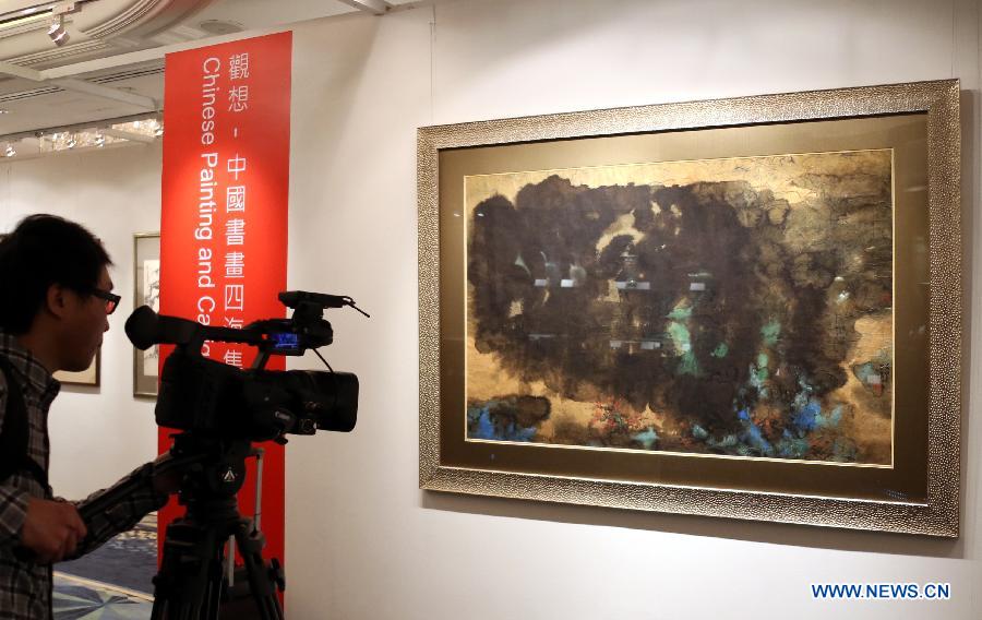 A TV journalist shoots a painting by Zhang Daqian estimated at a price of 12 million to 15 million HKD (about 1.5 million to 1.9 million U.S. dollars) during the preview of the Hong Kong 2013 Spring Auctions held by China Guardian Auctions Co.Ltd in Hong Kong, south China, April 3, 2013. The two-day auctions will start on April 4, with over 300 pieces of paintings and calligraphy as well as ceramic artworks. (Xinhua/Li Peng) 