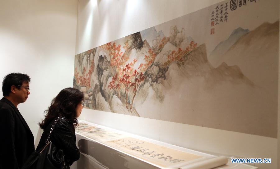 Visitors look at a painting by Wu Hufan estimated at a price of 8 million to 12 million HKD (about 1 million to 1.5 million U.S. dollars) during the preview of the Hong Kong 2013 Spring Auctions held by China Guardian Auctions Co.Ltd in Hong Kong, south China, April 3, 2013. The two-day auctions will start on April 4, with over 300 pieces of paintings and calligraphy as well as ceramic artworks. (Xinhua/Li Peng) 