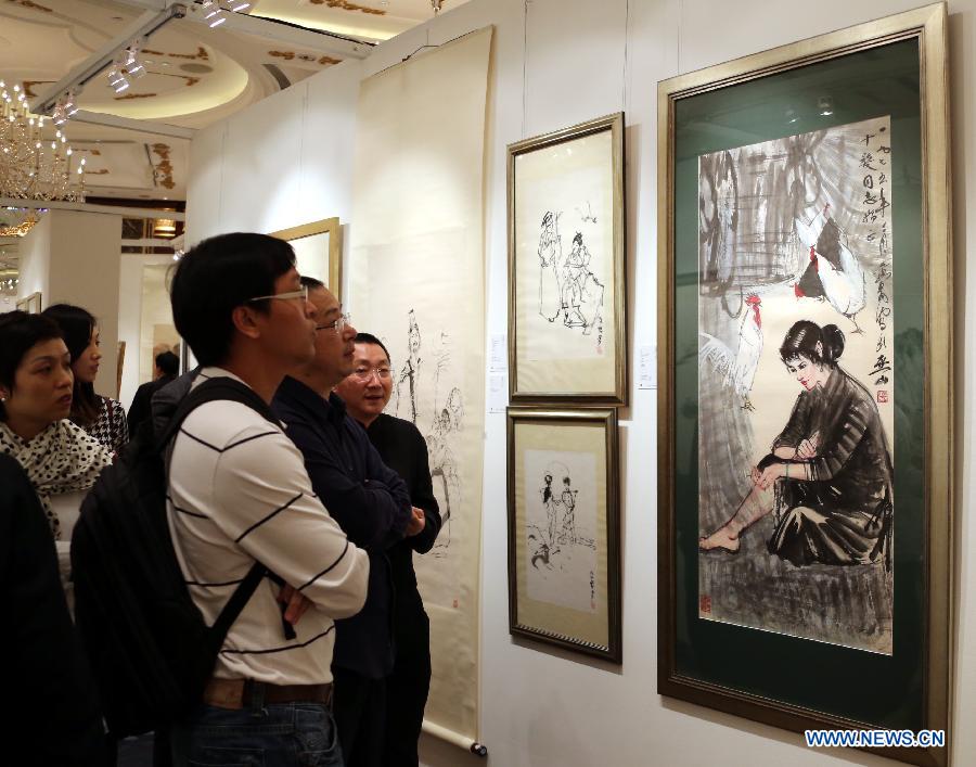 Visitors look at paintings during the preview of the Hong Kong 2013 Spring Auctions held by China Guardian Auctions Co.Ltd in Hong Kong, south China, April 3, 2013. The two-day auctions will start on April 4, with over 300 pieces of paintings and calligraphy as well as ceramic artworks. (Xinhua/Li Peng)