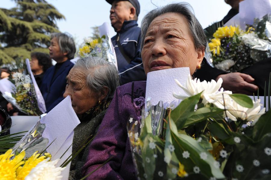 Shi Xiuying (R), the survivor of the Nanjing Massacre in 1937, attends a memorial ceremony in the Memorial Hall of the Victims in Nanjing Massacre by Japanese Invaders, in Nanjing, capital of east China's Jiangsu Province, April 4, 2013, also the Qingming Festival, or the Tomb-Sweeping Day. Lots of citizens came here to mourn Nanjing Massacre victims on Thursday. (Xinhua/Han Yuqing) 