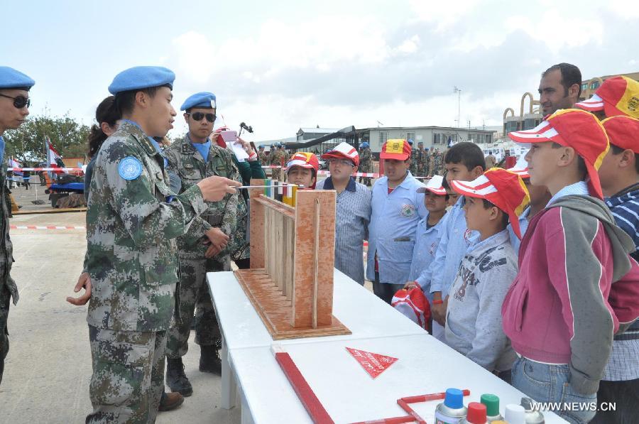 Chinese peacekeepers give a lesson to the local students about mine during an activity to mark the International Day of Mine Awareness and Assistance in Mine Action in Naqoura, southern Lebanon, April 4, 2013. The United Nations Interim Force in Lebanon (UNIFIL) observed Thursday the International Day of Mine Awareness and Assistance in Mine Action at its headquarters in Naqoura, southern Lebanon. (Xinhua/Liu Song)