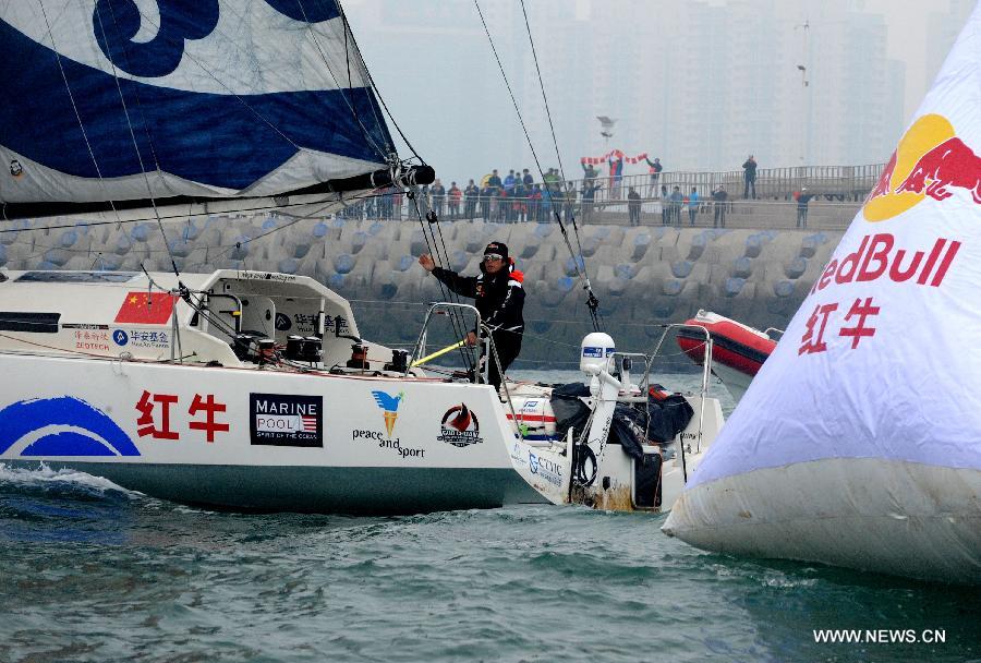China's Guo Chuan passes a finish buoy on his boat in Qingdao, east China's Shandong Province, April 5, 2013. Guo sailed back home on Friday morning to become the first Chinese to successfully circumnavigate the globe singlehanded. Aboard his Class40 yacht, 48-year-old Guo travelled about 21,600 nautical miles in 138 days before he returned to his hometown of Qingdao, where he set off on November 18 last year. (Xinhua/Li Ziheng)