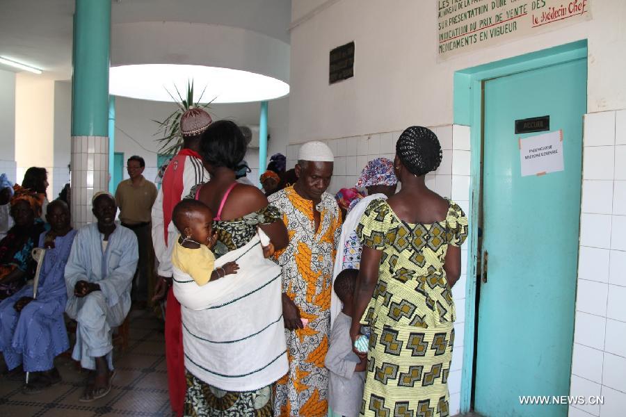 Patients wait outside a consulting room at the Hann/Mer Medical Center in Darkar, capital of Senegal, March 31, 2013. The 14th Chinese medical team in Senegal provided free medical service and medication to local people in Dakar on March 31. (Xinhua/Wang Meng)