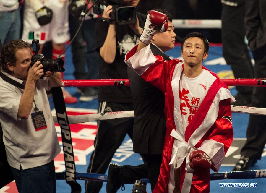 Two-time Olympic gold medalist China's Zou Shiming (R) waves to the audience before his professional debut against Mexico's Eleazar Valenzuela in Macau, China, April 6, 2013. (Xinhua/Cheong Kam Ka)