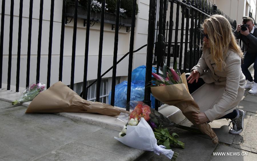 A girl presents floral tributes outside the residence of Baroness Thatcher in No.73 Chester Square in London, Britain, on April 8, 2013. Former British Prime Minister Margaret Thatcher died at the age of 87 after suffering a stroke, her spokesman announced Monday. (Xinhua/Wang Lili)