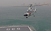 Warship in coordinated-drill with helicopter