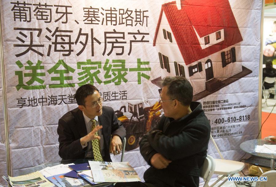 An real estate consultant introduces overseas property projects to a citizen at Beijing Spring Real Estate Trade Fair in Beijing, capital of China, April 11, 2013. The four-day fair kicked off on Thursday. (Xinhua/Luo Xiaoguang)